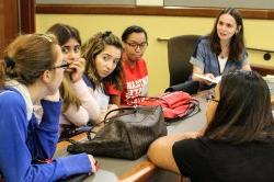 Image of faculty member Anna Feldman talking with Linguistics students.